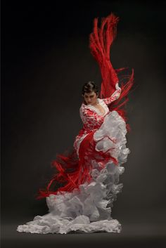 a woman in a red and white dress is dancing