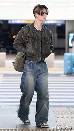 a young man is standing on the sidewalk