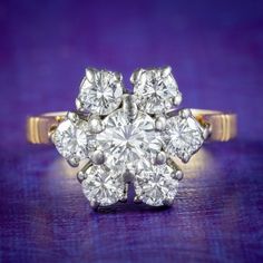 an antique diamond cluster ring on a purple background