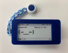 an electronic device with a face drawn on the screen next to a cord that is attached to it