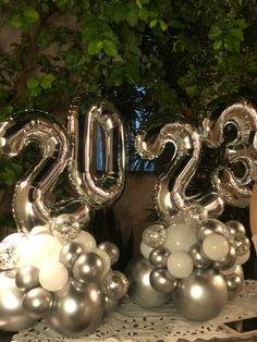 some balloons are sitting on a table with the numbers 2013 spelled out in silver and white