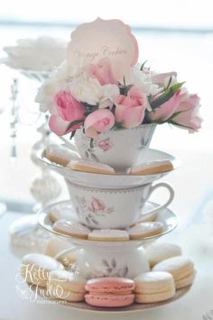 a stack of tea cups filled with pink and white flowers