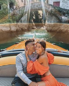 a man and woman sitting on the back of a boat