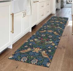 a kitchen area rug in the middle of a wooden floor with white cabinets and drawers