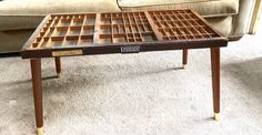 a coffee table made out of wooden squares on top of carpeted floor next to couch