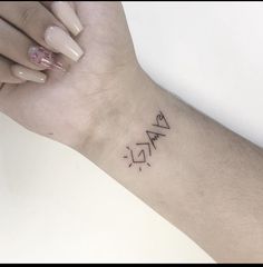 a woman's wrist with a small tattoo on it