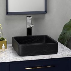 a bathroom sink sitting on top of a white counter next to a mirror and plant