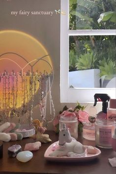 a wooden table topped with lots of pink and white stuff next to a vase filled with flowers