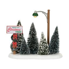 a christmas tree stand with a sign and street light