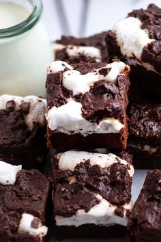 chocolate brownies with marshmallows on top and a glass of milk in the background