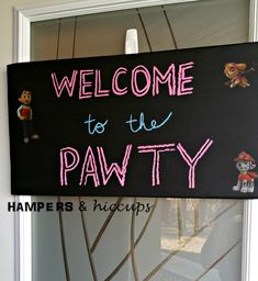 a welcome to the pawty sign hanging on a door