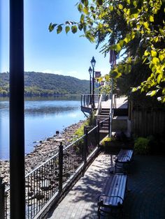 a bench sitting on the side of a road next to a lake