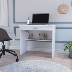 a laptop computer sitting on top of a white desk next to a potted plant