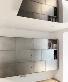 an empty room with stainless steel cabinets and bookshelves on the wall in front of it