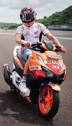 a man riding on the back of an orange motorcycle