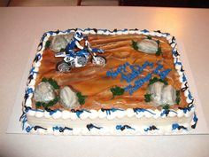 a birthday cake is decorated with an image of a motorcyclist on a dirt bike