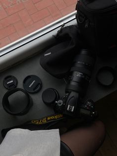 a camera and some other items are sitting on the floor next to a glass window