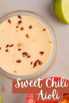 a bowl of sweet chili aioli next to an apple and lime slice on the side