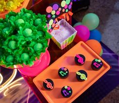 there are some cupcakes on the table with decorations around it and balloons in the background