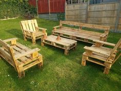 several wooden benches and chairs sitting in the grass