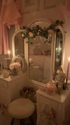 a bedroom with a vanity, mirror and stool next to a bed covered in pink roses