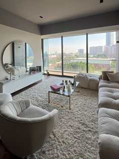 a living room filled with furniture and a large mirror on the wall above it's windows