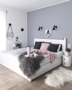 a white bed sitting in a bedroom on top of a hard wood floor