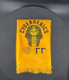 a yellow towel with the emblem of an egyptian temple on it's back side