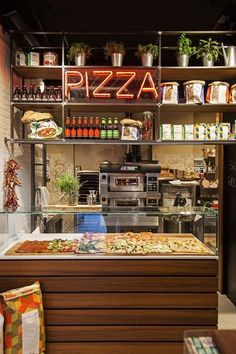 a pizza bar with lots of different types of toppings on the counter and shelves