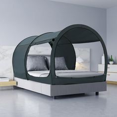 a bed with a canopy over it in the middle of a room next to a wall