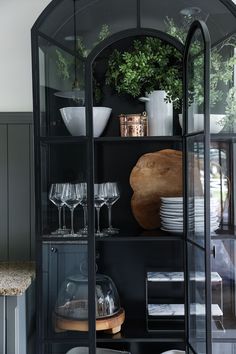 a glass cabinet with plates and glasses in it