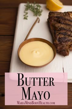 grilled steak with butter mayo in a bowl on a cutting board next to lemon wedges