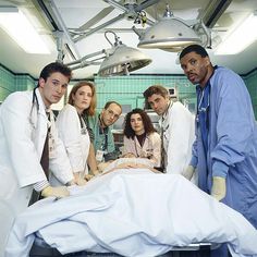 doctors and nurses standing around a woman in a hospital bed