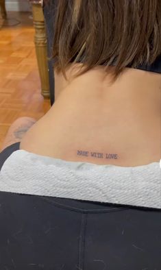 a woman with a tattoo on her back that says, make it home in cursive writing