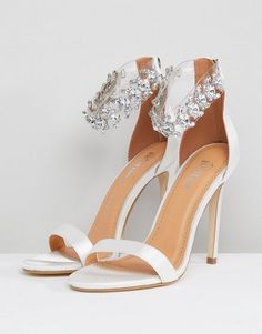 a pair of white high heeled sandals with jewel embellishments