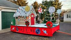 an outdoor christmas display in front of a house with trees and candy canes on it