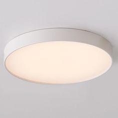 a white circular light fixture mounted on a wall