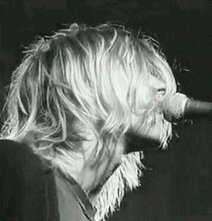 a woman with blonde hair singing into a microphone