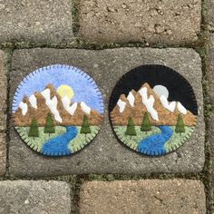 two plates with mountains painted on them sitting on the ground