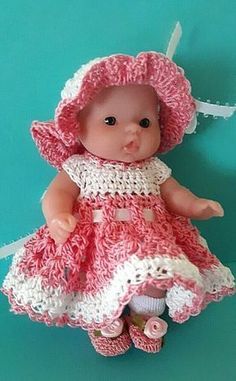 a baby doll wearing a pink dress and hat