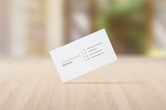 a white business card sitting on top of a wooden table