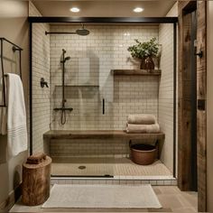 a walk in shower sitting next to a wooden shelf filled with towels and other items