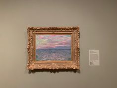 a painting hanging on the wall next to a white and gray wall with an ocean scene