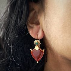 Our gorgeous oval Green and Red Onyx Dangle Earrings in 18K gold plated plated on sterling silver are the perfect addition to your jewellery collection. Pair these premium, yet affordable green and red gemstone earrings with your everyday outfits to add a touch of style and luxury to your look. LOOK AND FEEL Carigari is committed to providing you with the same premium feeling of some of the biggest names in the industry for an affordable price tag.  MEASUREMENTS Earring length (with hook): 47mm Red Gemstone Gold-plated Earrings, Red Gemstone Gold Plated Earrings, Traditional Oval Red Earrings, Traditional Red Oval Earrings, Elegant 22k Gold Gemstone Earrings, Elegant 22k Gold Danglers As Gift, Elegant 22k Gold Danglers For Gift, Gold Oval Earrings For Festive Occasion, Temple Jewelry Gemstone Danglers For Gift