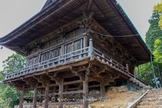 a tall wooden building sitting on top of a hill