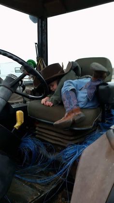 a man laying on the back of a truck covered in blue wires and other things