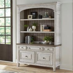 a large white bookcase with drawers and shelves