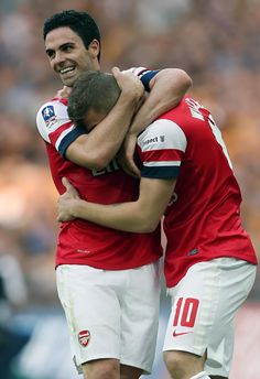 two soccer players are hugging each other on the field