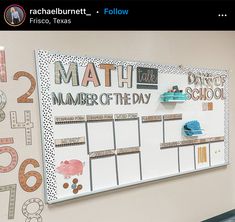 a bulletin board is hanging on the wall in an office area with numbers and school supplies