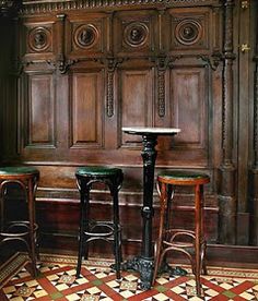 two stools sitting next to each other in front of a wooden paneled wall